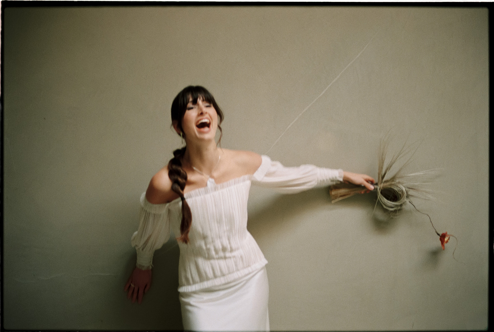 Laughing bride with a bouquet of dried grasses, editorial styled by Studio Kowalski in Portugal